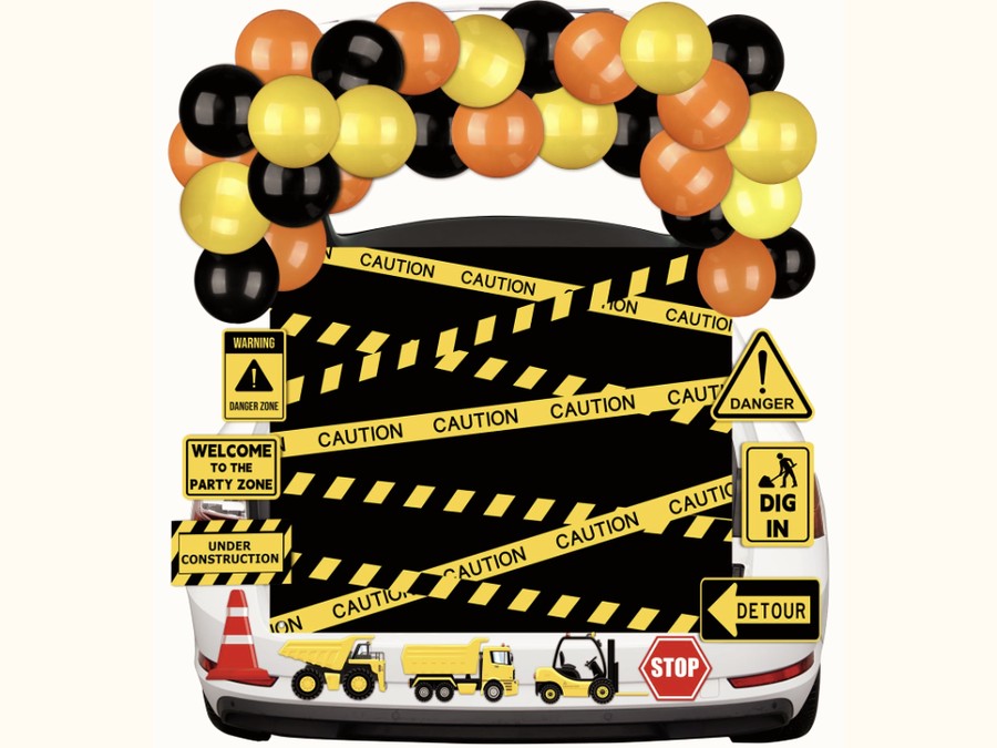 Construction themed trunk with caution tape, balloons, and toy trucks